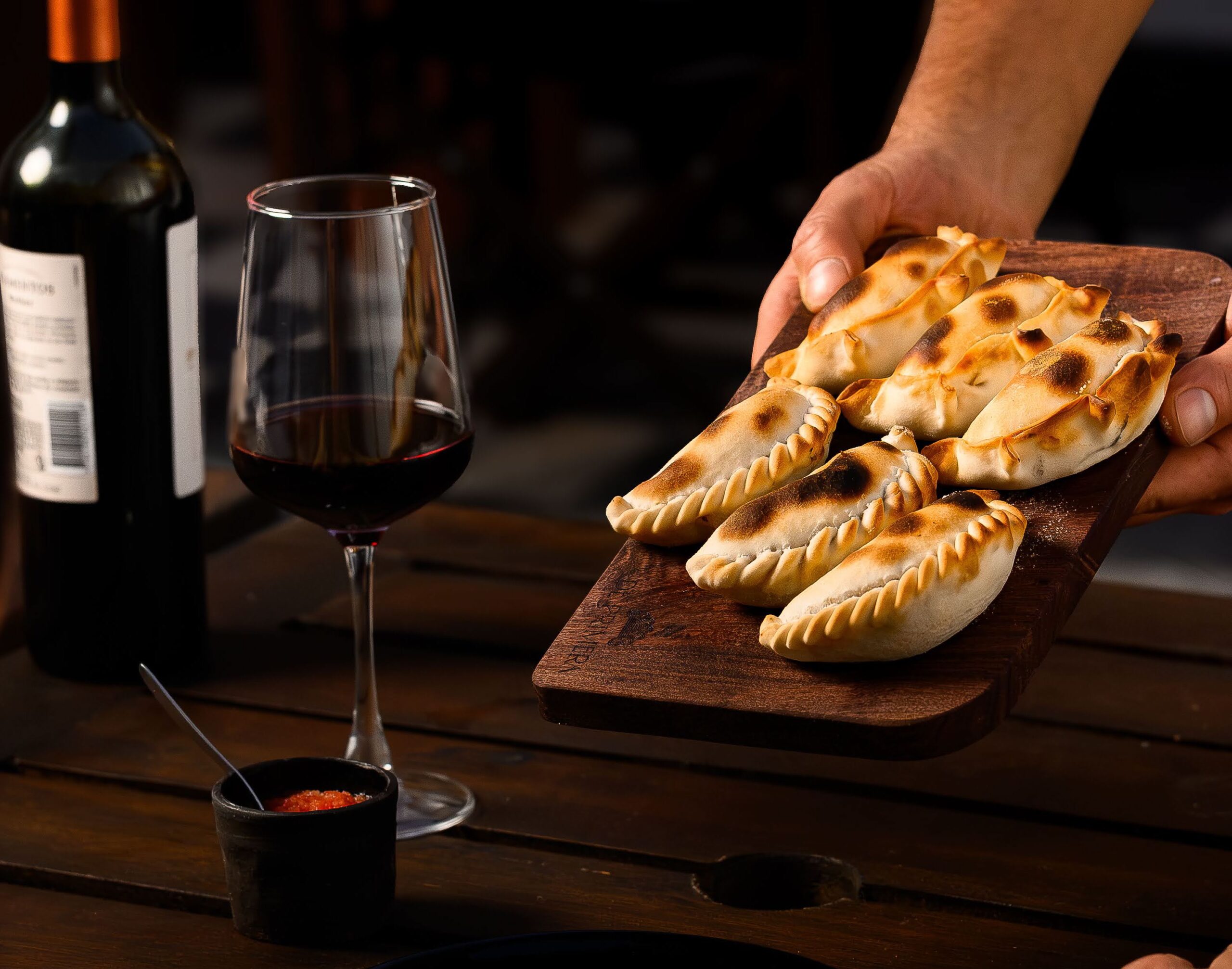 De Primera Empanadas Servidas en la Mesa con Copa de Vino